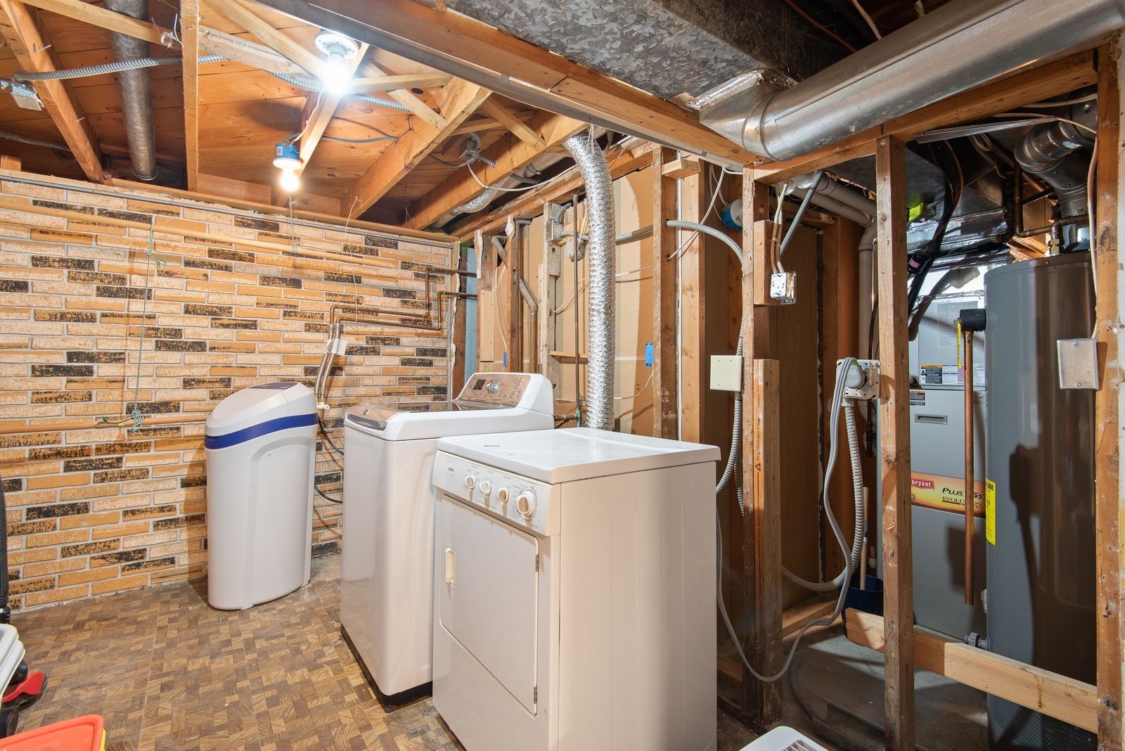 A basement mechanical room with a water heater, softener, and utilities